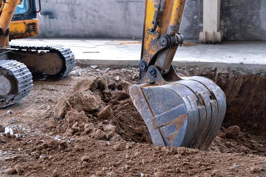Excavator bucket digging into earth